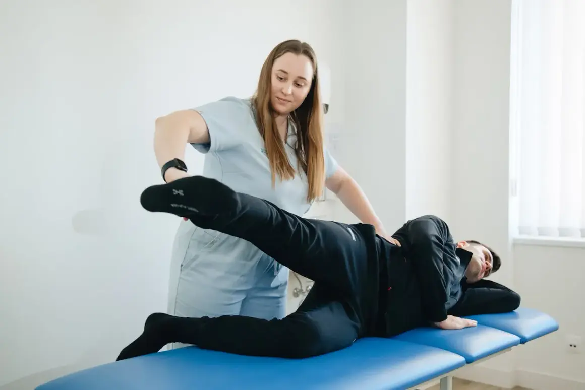 Fizjoterapeutka pomaga pacjentowi z bólem stawu lisfranca w ćwiczeniach rehabilitacyjnych.